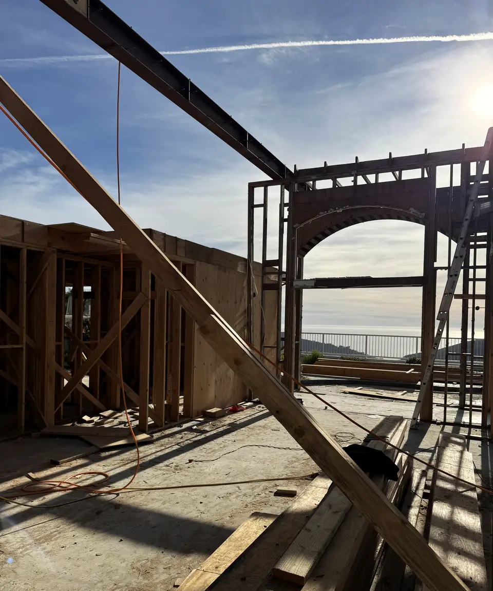 A steel beam spanning a new architectural opening above the ocean on an Orange County hillside build