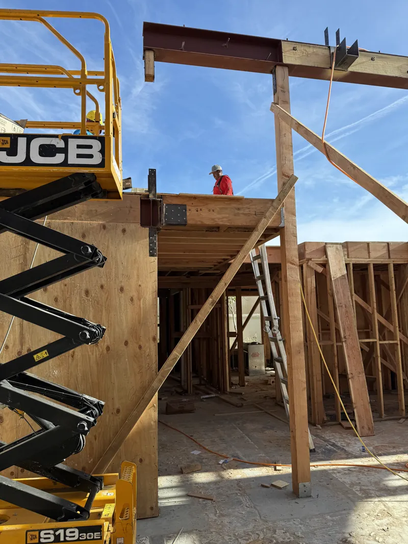 A beam being positioned by lift above the formed walls