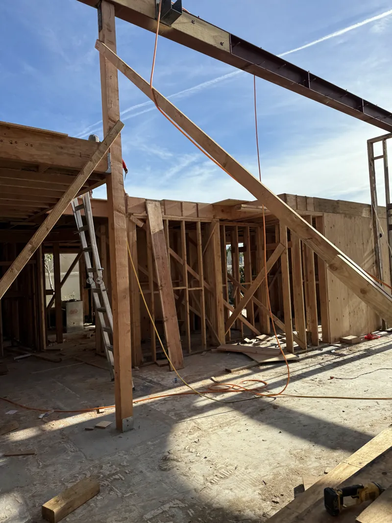 The installed steel beam spanning the new framed opening